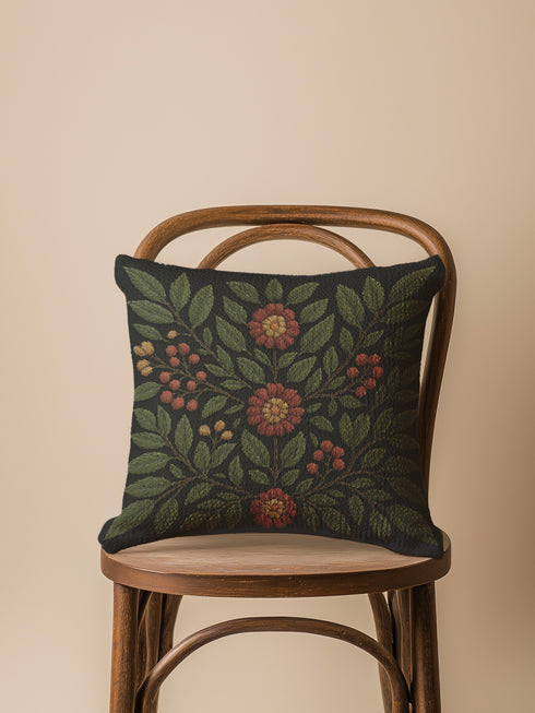A 17x18 inch woven tapestry pillow featuring a dark green background with embroidered rowan leaves, berries, and rust-toned flowers. The pillow is double-sided, filled with plush poly fill, and sewn shut for a seamless, soft finish. Made from 58% cotton and 42% polyester yarns, this decorative cushion adds a cozy, mystical charm to any cottagecore, gothic, or forest-inspired home.